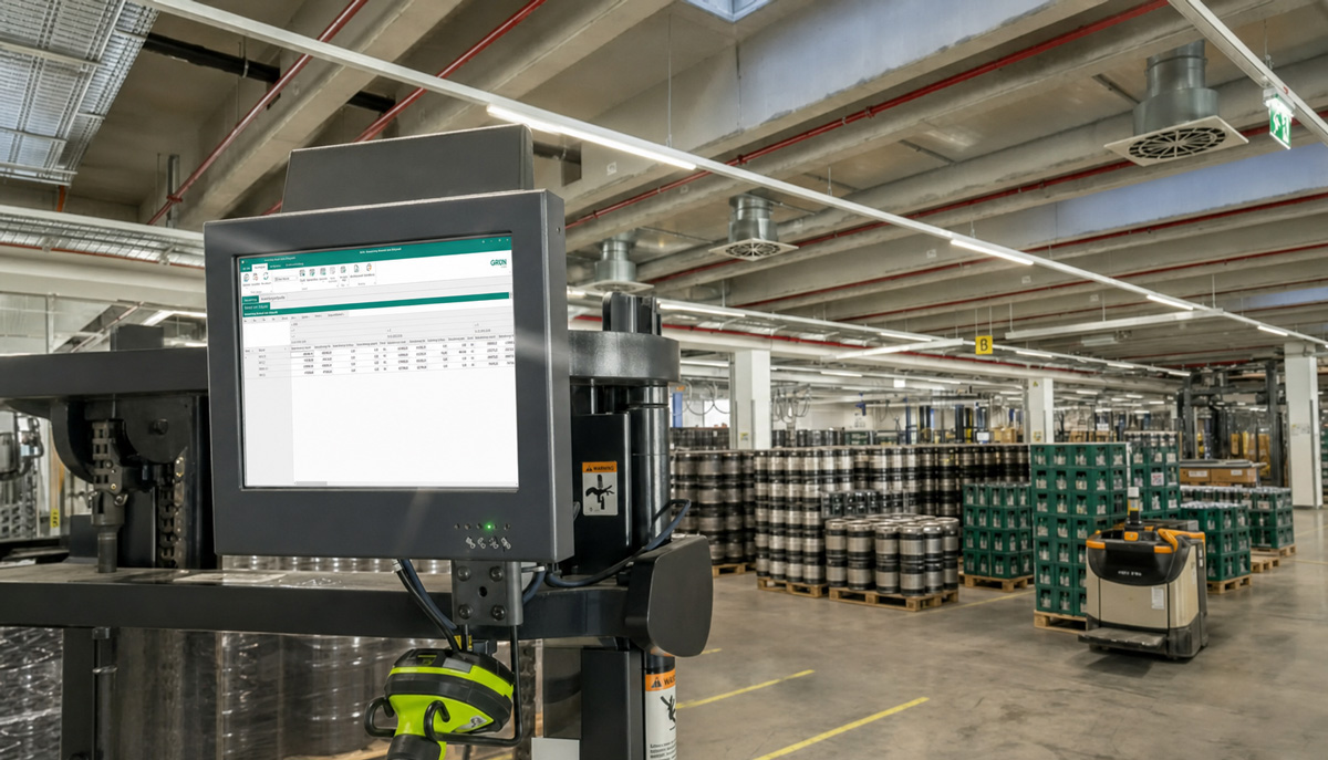 Bestandsanalyse in einer Lagerhalle: Industriemonitor zeigt Software zur Bestandsauswertung, im Hintergrund stehen Kartons auf Paletten.