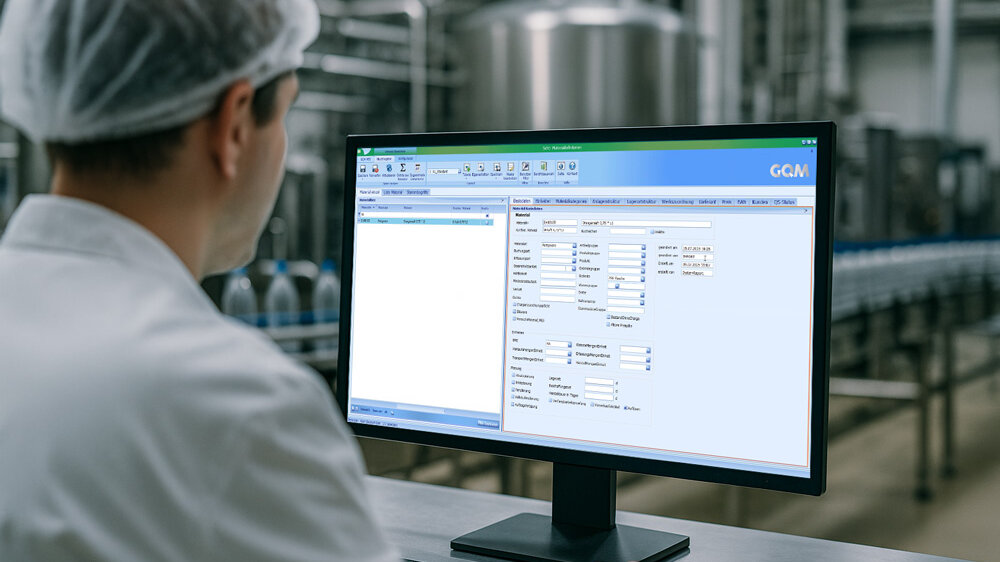 Mitarbeiter in Produktionshalle überwacht die Datenübernahme im GQM MES-System.